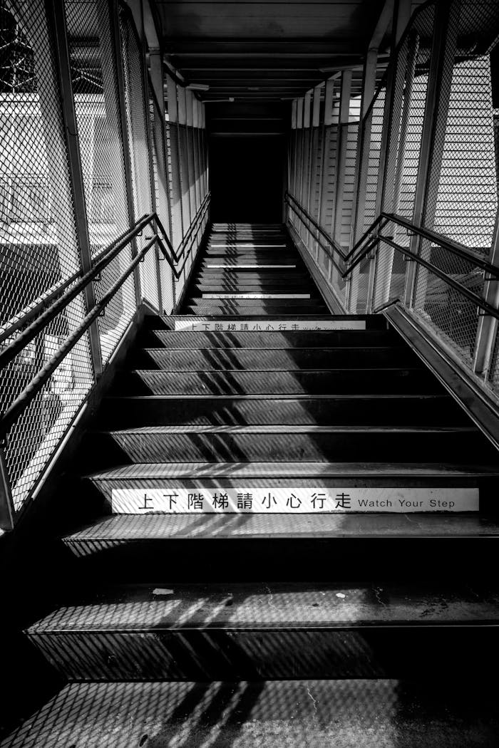 Grayscale stairs with dramatic shadows, featuring caution sign in Taiwan.